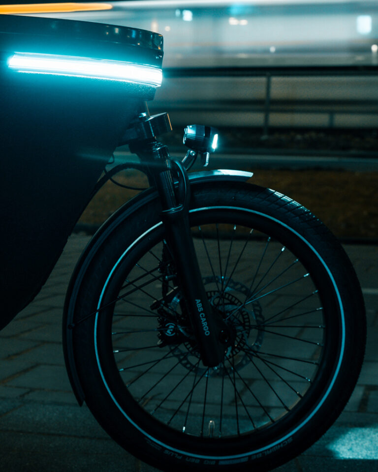 Front wheel and ABS Cargo suspension fork with illuminated LED light of the Lovens Explorer 2 cargo bike at night